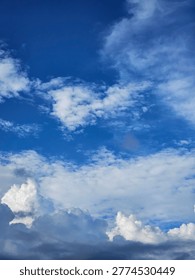 High angle view of white fluffy cumulus clouds against a deep blue sky.