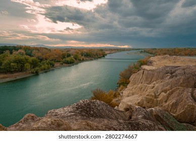 High angle view of a wide river flowing through rocky cliffs and autumn forest