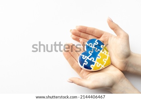 High angle view of woman hands holding ukraine flag painted heart isolated on white background