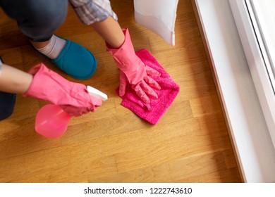 High angle view of woman wearing protective gloves and cleaning floor with floor disinfectatnt cleaner