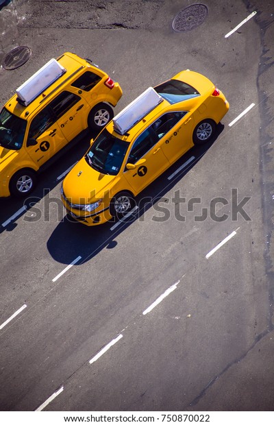 High angle view of yellow taxis on a New-York street\
on a sunny day.