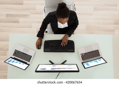 High Angle View Of A Young African Woman Analyzing Graph In Office