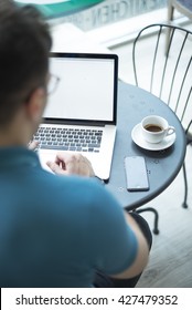 High Angle View Of Young Business Using His Laptop In Coffee Shop