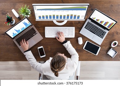 High Angle View Of Young Businesswoman Working With Graphs On Computer