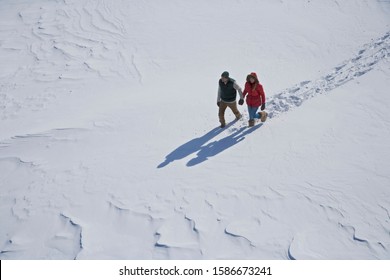 High Angle View Of Young Couple Walking In Snow