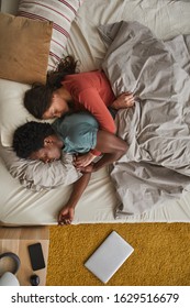 High angle view of young family relaxing in bed they embracing each other and sleeping