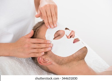 High Angle View Of Young Man In Spa Salon With Facial Mask