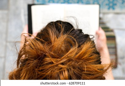 High Angle View Of Young Woman Reading A Book