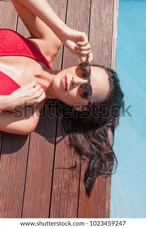 Similar – Brunette surfer woman in bikini standing with surfboard