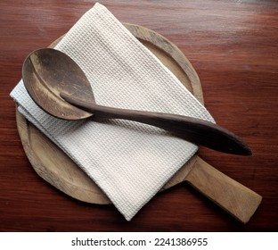 High angle of wooden kitchen utensils, coconut shell laddle, napkin and chopping board, environmental friendly