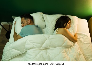 High Angle Of A Young Couple Sleeping Apart On The Bed After A Fight. Young Woman And Man Resting On A Comfy Bed