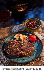 High Angle Of Yummy Grilled Vegetables And Beef Steak Placed Near Bowl With Sauce On Wooden Table With Snow For Winter Barbeque