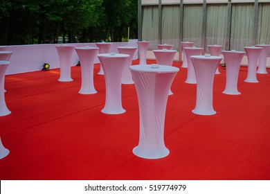 High Bar Tables Covered With White Cloth Stand Over The Red Floor