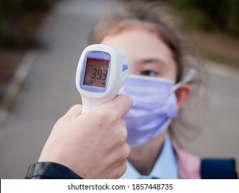 High Body Temperature. The Girl Is Measured The High Temperature Outside. Epidemic. Back To School During Quarantine