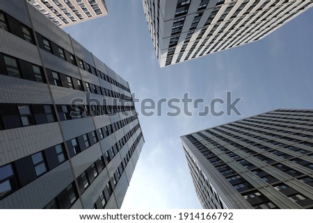 High bottom up perspective view of modern city tower buildings with many windows in the urban cluster