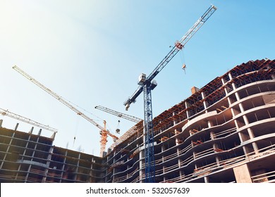 High building under construction. Side with cranes against blue sky with sun glare. - Shutterstock ID 532057639