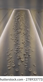 High ceiling interior focus showcasing a tall vertical artwork strip decorated with handmade carvings over stucco venetian plaster.                             