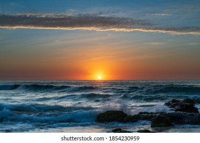 High clouds over the sea, a pretty sunrise seascape from Killcare Beach on the Central Coast, NSW, Australia.