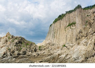 high coastal cliff formed by solidified lava stone columns, Cape Stolbchaty on Kunashir island  - Shutterstock ID 2211895001