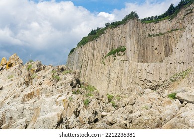 high coastal cliff formed by solidified lava stone columns, Cape Stolbchaty on Kunashir island  - Shutterstock ID 2212236381