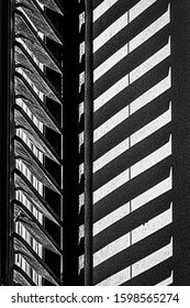 High Contrast Black And White Photograph Of A Partially Open Window Shutter And Its Shadow On A Wall In Sighisoara Romania