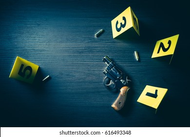 High Contrast Image Of A Crime Scene With Gun And Markers On The Floor