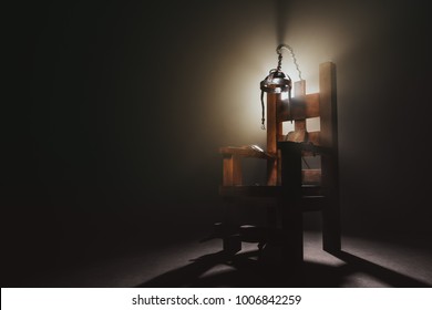 High contrast image of an electric chair scale model on a dark backgorund with smoke