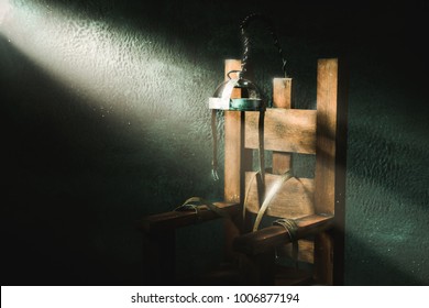 High contrast image of an electric chair scale model on a dark backgorund with light rays