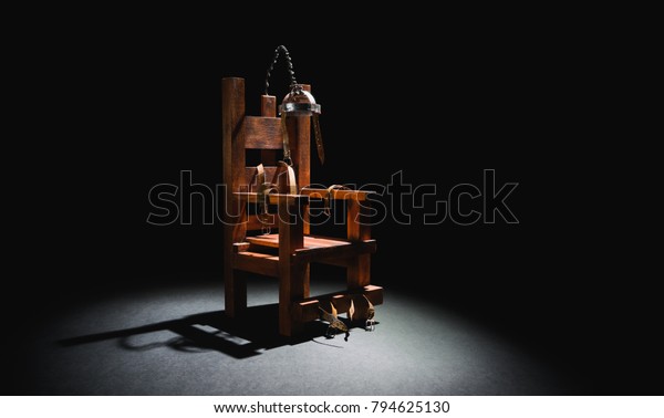 High contrast image of an electric chair scale\
model on a dark backgorund