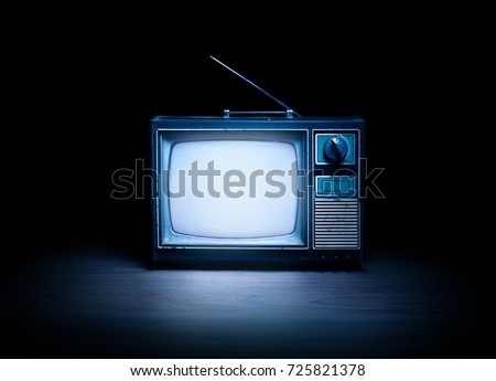 High contrast image of an old vintage TV with white noise on white wood.
