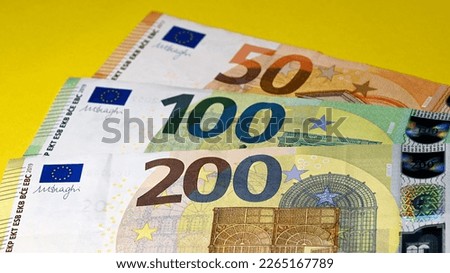 High detail closeup of €350.00 in €200.00, €100.00 and €50.00 banknotes isolated on yellow background
