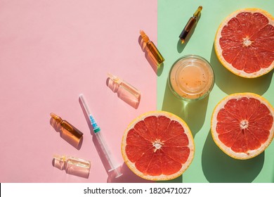 High dose vitamin C, ampule for injection, face cream, syringe and fresh juicy orange fruit slides. Concept of vitamin,mineral supplement, beauty,cosmetic product and health nutrition. Copy space.