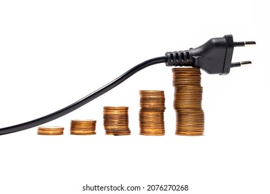 high electricity costs due to excessive energy use. impact of not using energy-efficient equipment. there is a power cord on several stacks of coins. ever-increasing electricity costs. 