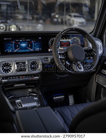 A high end car interior featuring a digital dashboard, steering wheel, and console with illuminated controls.