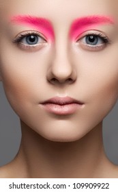 High Fashion And Beauty Portrait Photography. Beautiful Girl Model Face With Creative Bright Makeup Like A Doll, Clean Skin, Pale Lips And Vibrance Eyebrows.