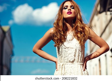 High Fashion Look.glamor Beautiful Sexy Stylish Blond Young Woman Model With Bright Makeup And Pink Lips With Perfect Clean Skin In White Summer Dress In The City Behind Blue Sky