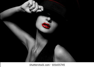 High fashion look.glamour portrait of beautiful sexy young female woman with red lips on black background with hat