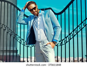 High Fashion Look.Young Stylish Confident Happy Handsome  Businessman Model Man In Blue Suit Cloth Lifestyle In The Street Behind Sky In Sunglasses