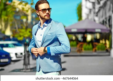 High fashion look.Young stylish confident happy handsome businessman model in suit clothes walking in the street in sunglasses - Powered by Shutterstock