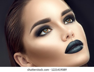 High Fashion Model Girl Portrait with Trendy gothic Black make-up. Young woman with black lipstick, dark smokey eyes, face contouring, beauty eyebrows. Perfect Smoky eyes makeup. Beautiful skin