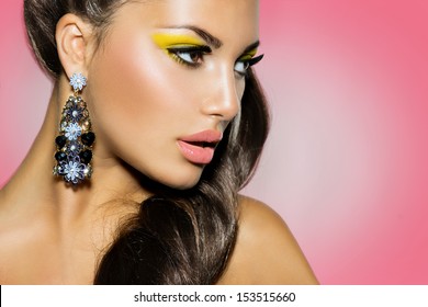 High Fashion Model Girl Portrait over Pink Background. Creative Make up. Yellow Eyeshadow, Ponytail Hairstyle, Trendy Earrings. Perfect Skin - Powered by Shutterstock