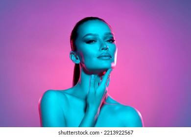 High fashion model metal silver lips and face woman in colorful bright neon UV blue and purple lights, posing in studio, beautiful girl, glowing makeup, colorful makeup. Glitter Bright Neon Makeup - Shutterstock ID 2213922567