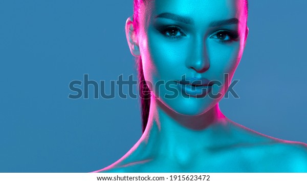 High fashion model metal silver lips and face\
woman in colorful bright neon UV blue and purple lights, posing in\
studio, beautiful girl, glowing makeup, colorful makeup. Glitter\
Bright Neon Makeup