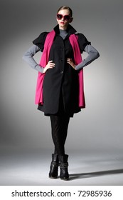High fashion model in scarf wearing sunglasses posing in the studio