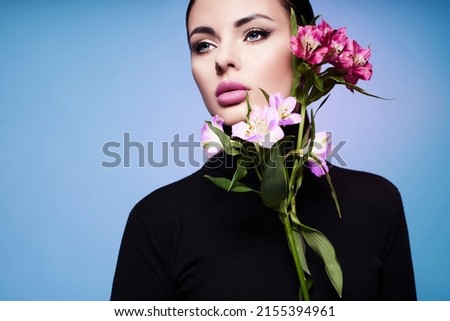  A high fashion model with spring and summer colors. A woman in a colorful bright blue and purple light, posing in a studio, a beautiful girl, colorful makeup.                                