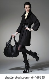 High Fashion Model In Winter Fur Coat Clothes With Bag Posing In The Studio