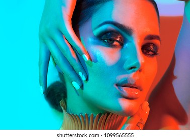 High Fashion model woman in colorful bright lights posing in studio, portrait of beautiful sexy girl with trendy make-up and manicure. Neon Art design, colorful make up. On colourful vivid background