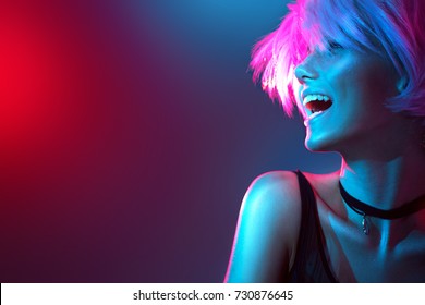 High Fashion model woman in colorful bright lights posing, portrait of beautiful  girl with trendy make-up. Art design, colorful make up. Over colourful vivid background