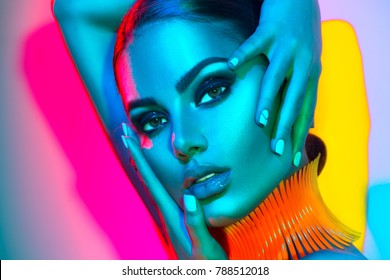 High Fashion Model Woman In Colorful Bright Lights Posing In Studio, Portrait Of Beautiful Sexy Girl With Trendy Make-up And Manicure. Art Design, Colorful Make Up. Over Colourful Vivid Background.