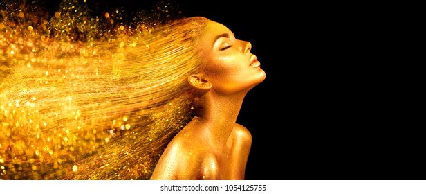 High Fashion Model Woman In Golden Bright Sparkles. Art Gold Skin Girl Face Portrait Closeup. Beauty Gold Eyes, Lips, Skin And  Dyed Hair. Lady With Holiday Glamour Shiny Professional Makeup On Black